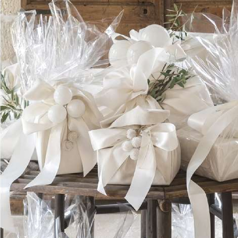 Lovely white Christmas gifts wrapped in silk and cellophane - Pamela Pierce for Milieu magazine. #whitechristmasdecor #giftwrapping #elegantholiday #milieumag #pamelapierce