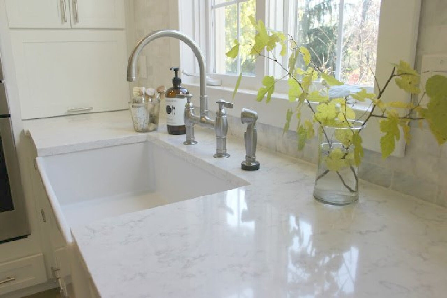 White modern farmhouse kitchen with Minuet quartz countertop and farm sink by Hello Lovely Studio. #minuet #viatera #quartz #kitchendesign