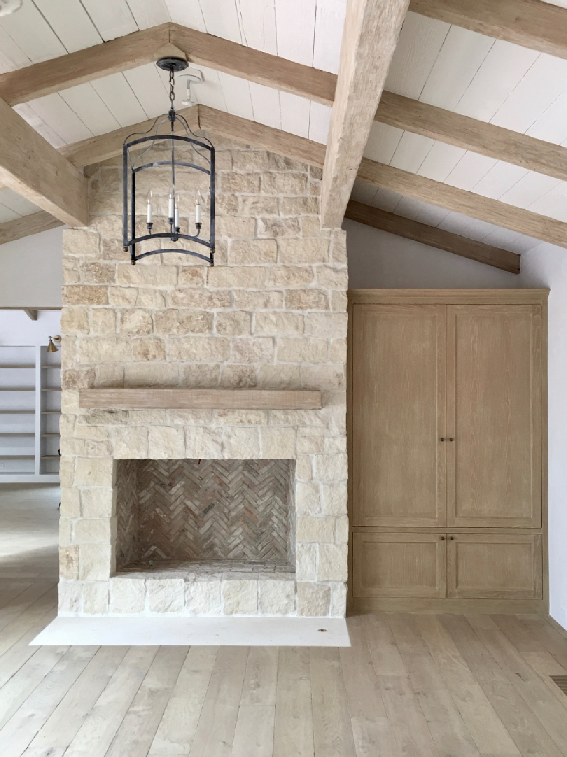 Limestone fireplace and white oak cabinetry. Steve Giannetti designed modern Mediterranean Malibu home with white oak, natural finishes, limestone, and Old World style. #giannettihome #patinastyle #patinahomes