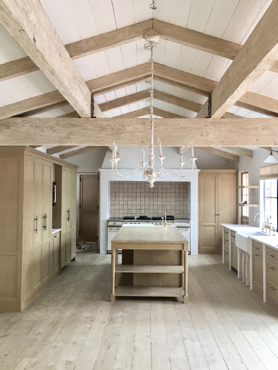 Kitchen with white oak beams, cabinets and flooring. Steve Giannetti designed modern Mediterranean Malibu home with white oak, natural finishes, limestone, and Old World style. #giannettihome #patinastyle #patinahomes