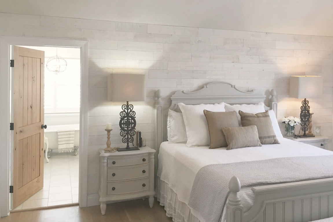 White French country cottage bedroom with Stikwood (hamptons) statement wall, white oak hardwood, and rustic alder doors. #hellolovelystudio #frenchcountry #bedroomdecor #rusticelegance #whiteoak #frenchbedrooms #alderdoor #stikwood #hamptons #romanticdecor #whitebedrooms #interiordesign