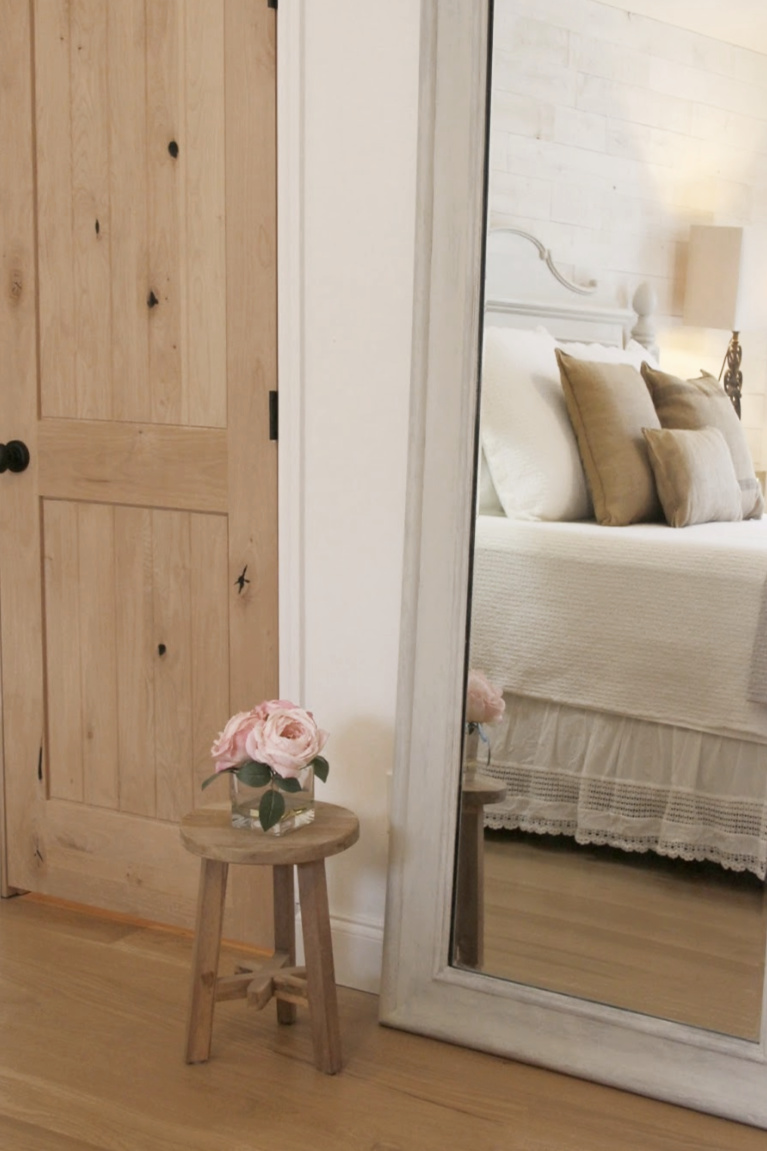 White French country cottage bedroom with Stikwood (hamptons) statement wall, white oak hardwood, and rustic alder doors. #hellolovelystudio #frenchcountry #bedroomdecor #rusticelegance #whiteoak #frenchbedrooms #alderdoor #stikwood #hamptons #romanticdecor #whitebedrooms #interiordesign