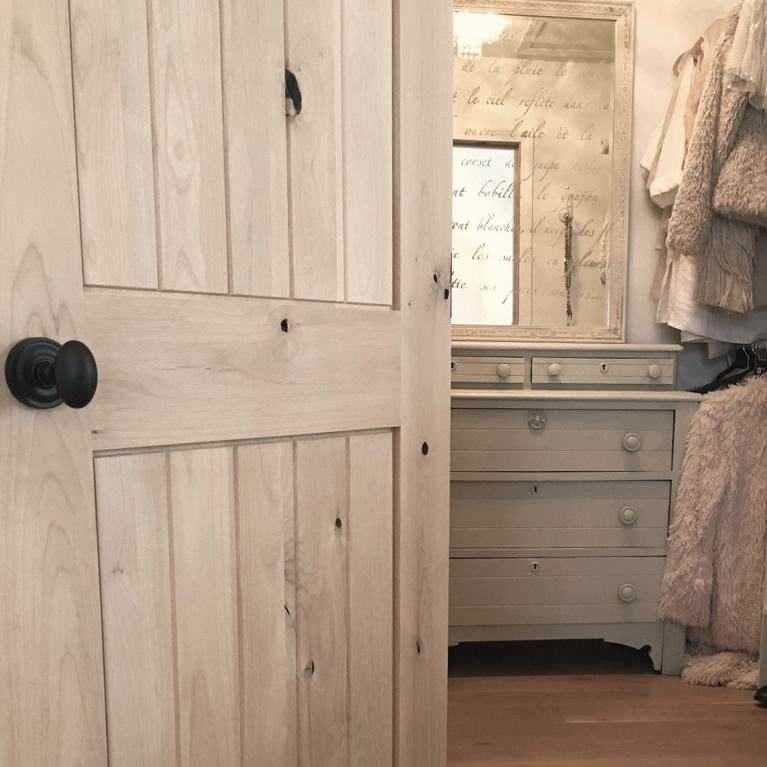 White French country cottage bedroom with Stikwood (hamptons) statement wall, white oak hardwood, and rustic alder doors. #hellolovelystudio #frenchcountry #bedroomdecor #rusticelegance #whiteoak #frenchbedrooms #alderdoor #stikwood #hamptons #romanticdecor #whitebedrooms #interiordesign