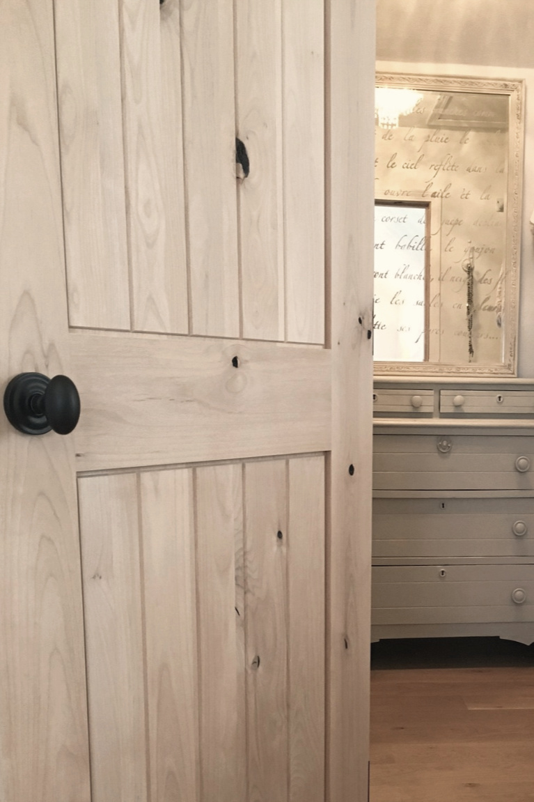 White French country cottage bedroom with Stikwood (hamptons) statement wall, white oak hardwood, and rustic alder doors. #hellolovelystudio #frenchcountry #bedroomdecor #rusticelegance #whiteoak #frenchbedrooms #alderdoor #stikwood #hamptons #romanticdecor #whitebedrooms #interiordesign