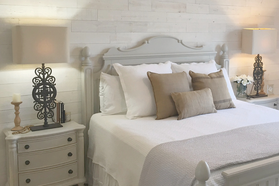 White French country cottage bedroom with Stikwood (hamptons) statement wall, white oak hardwood, and rustic alder doors. #hellolovelystudio #frenchcountry #bedroomdecor #rusticelegance #whiteoak #frenchbedrooms #alderdoor #stikwood #hamptons #romanticdecor #whitebedrooms #interiordesign