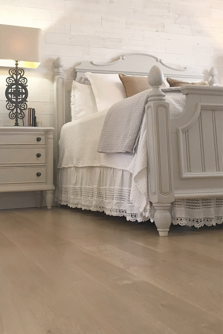 White French country cottage bedroom with Stikwood (hamptons) statement wall, white oak hardwood, and rustic alder doors. #hellolovelystudio #frenchcountry #bedroomdecor #rusticelegance #whiteoak #frenchbedrooms #alderdoor #stikwood #hamptons #romanticdecor #whitebedrooms #interiordesign