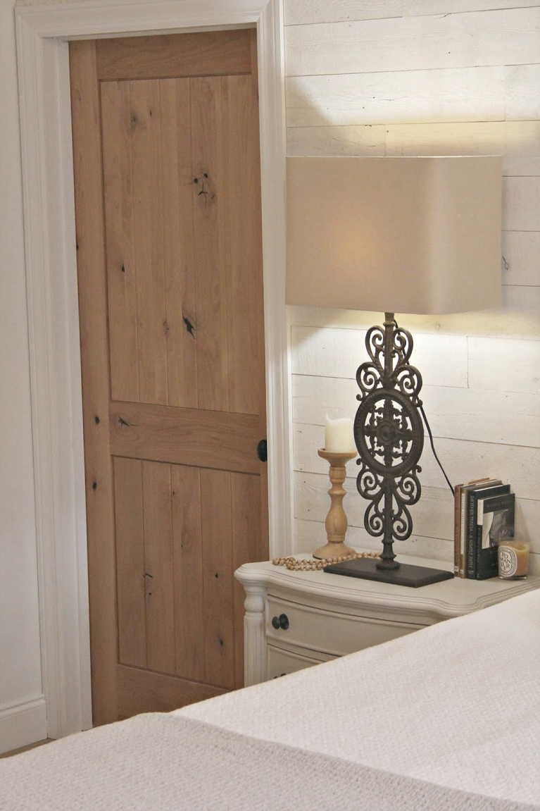 White French country cottage bedroom with Stikwood (hamptons) statement wall, white oak hardwood, and rustic alder doors. #hellolovelystudio #frenchcountry #bedroomdecor #rusticelegance #whiteoak #frenchbedrooms #alderdoor #stikwood #hamptons #romanticdecor #whitebedrooms #interiordesign