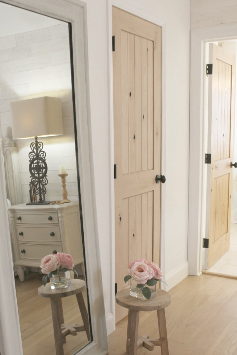 White French country cottage bedroom with Stikwood (hamptons) statement wall, white oak hardwood, and rustic alder doors. #hellolovelystudio #frenchcountry #bedroomdecor #rusticelegance #whiteoak #frenchbedrooms #alderdoor #stikwood #hamptons #romanticdecor #whitebedrooms #interiordesign