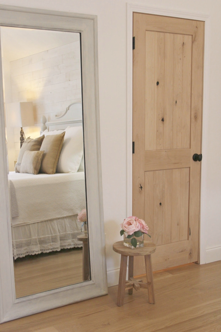 White French country cottage bedroom with Stikwood (hamptons) statement wall, white oak hardwood, and rustic alder doors. #hellolovelystudio #frenchcountry #bedroomdecor #rusticelegance #whiteoak #frenchbedrooms #alderdoor #stikwood #hamptons #romanticdecor #whitebedrooms #interiordesign