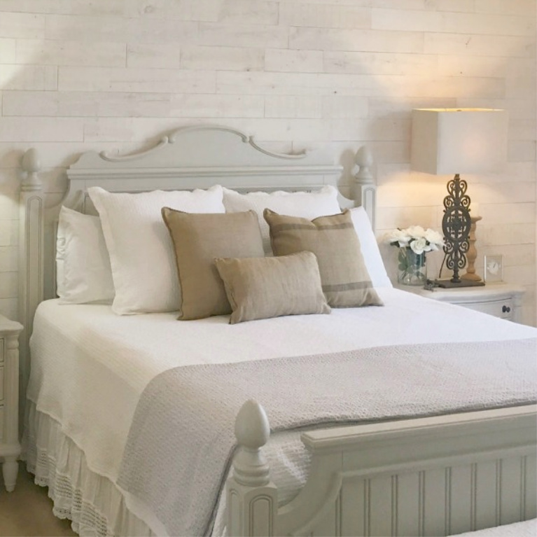 White French country cottage bedroom with Stikwood (hamptons) statement wall, white oak hardwood, and rustic alder doors. #hellolovelystudio #frenchcountry #bedroomdecor #rusticelegance #whiteoak #frenchbedrooms #alderdoor #stikwood #hamptons #romanticdecor #whitebedrooms #interiordesign