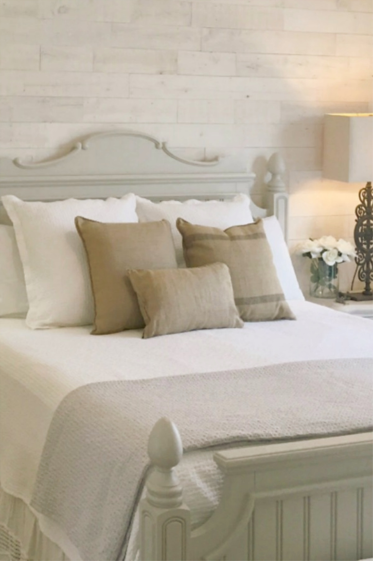 White French country cottage bedroom with Stikwood (hamptons) statement wall, white oak hardwood, and rustic alder doors. #hellolovelystudio #frenchcountry #bedroomdecor #rusticelegance #whiteoak #frenchbedrooms #alderdoor #stikwood #hamptons #romanticdecor #whitebedrooms #interiordesign