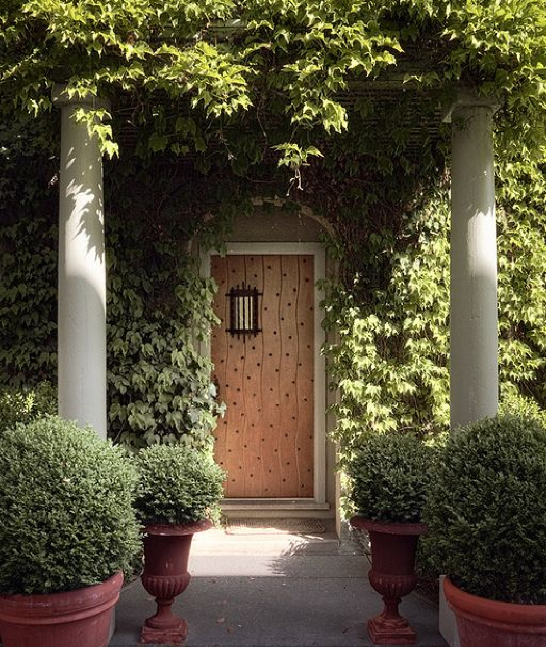 Front door and columns of interior designer Myra Hoefer's beautiful 1935 California cottage with Parisian interiors and French inspired gardens.