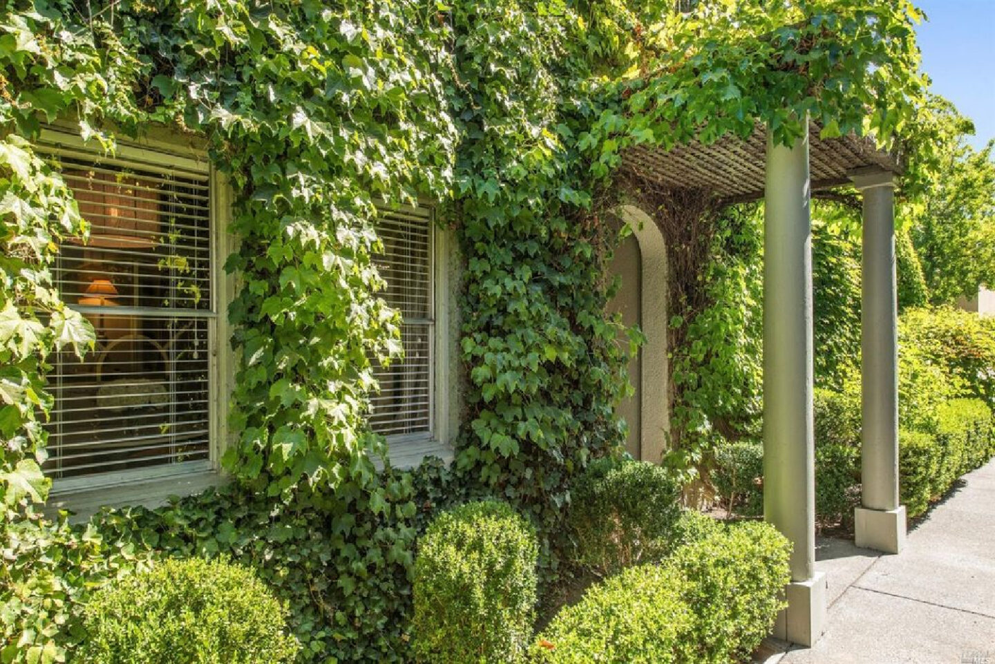 Vine covered exterior of interior designer Myra Hoefer's beautiful 1935 California cottage with Parisian interiors and French inspired gardens.