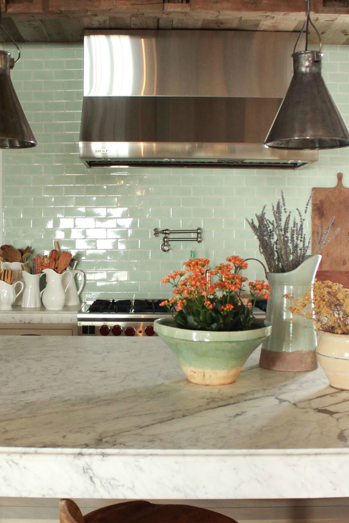 Green glazed subway tile in #FrenchCountry kitchen with stainless range hood #subwaytile