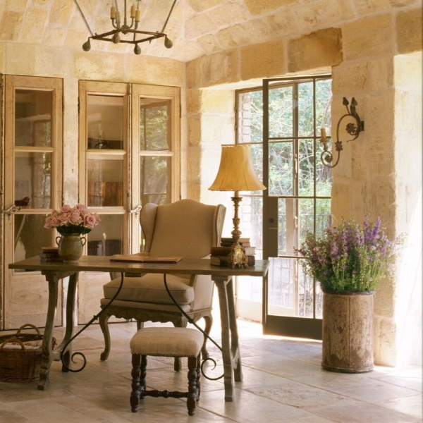 Breathtaking French country interior design in an office with reclaimed ancient limestone from France, lantern, linen, and rustic European antiques - Chateau Domingue. #frenchcountry #interiordesign #limestone #rusticdecor #frenchfarmhouse #chateaudomingue #frenchhouse