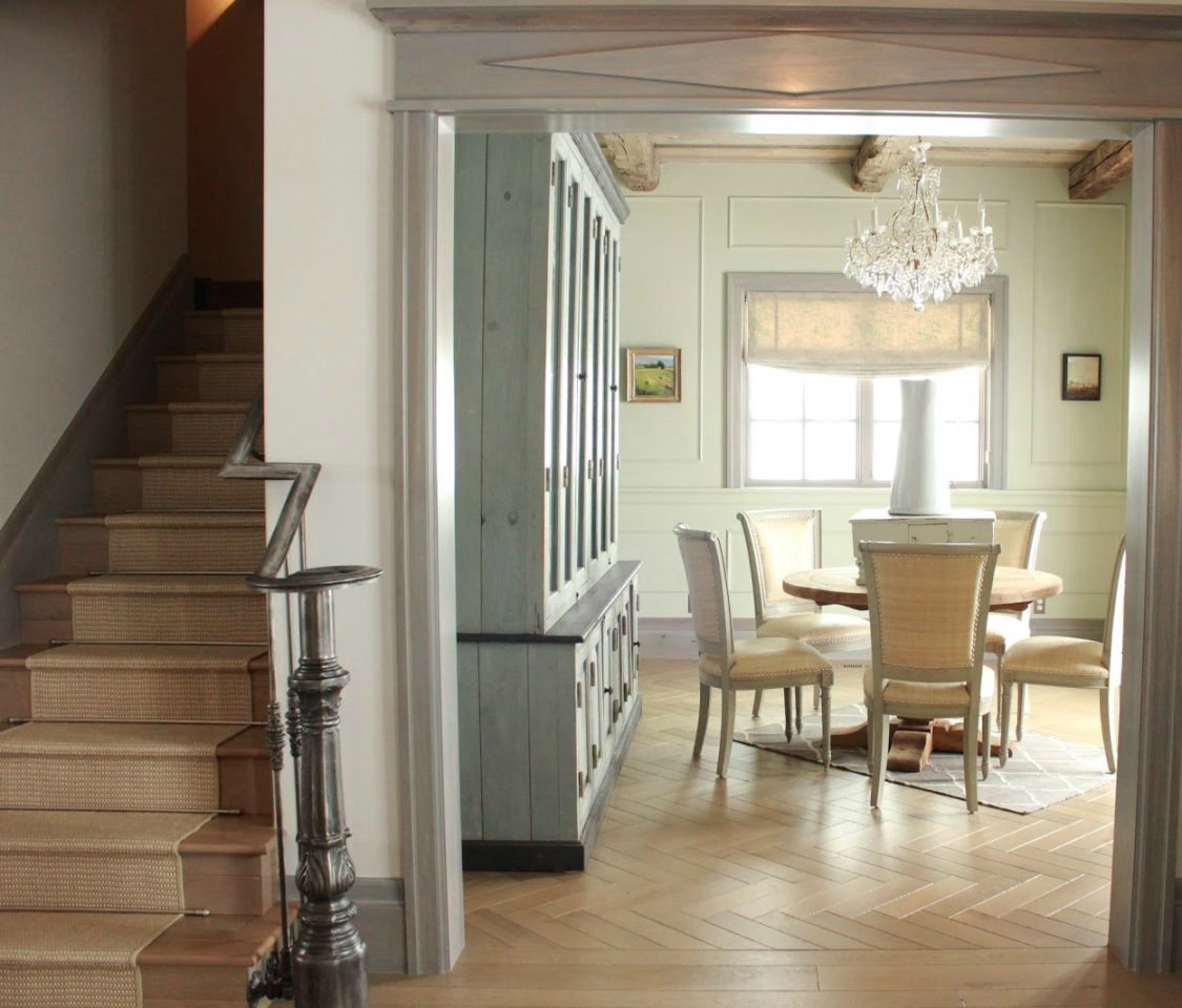 Entry and dining room with antique cabinet in French Country cottage on Hello Lovely