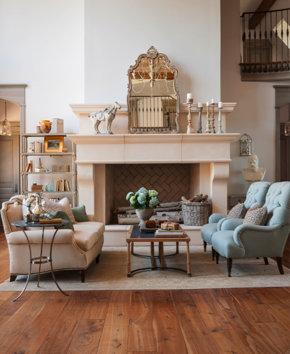 French limestone fireplace, rustic knotty wood floors, and a serene palette in this #FrenchCountry #livingroom by Decor de Provence. #limestonefireplace