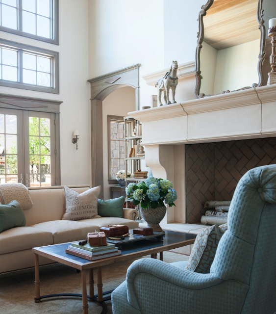 Stunning living room in a French inspired new build in Utah with grand French limestone fireplace and neutral interiors. Trim is a custom stained blue grey which imparts a Nordic feel. Decor de Provence. #FrenchCountry #FrenchNordic #livingroomdecor