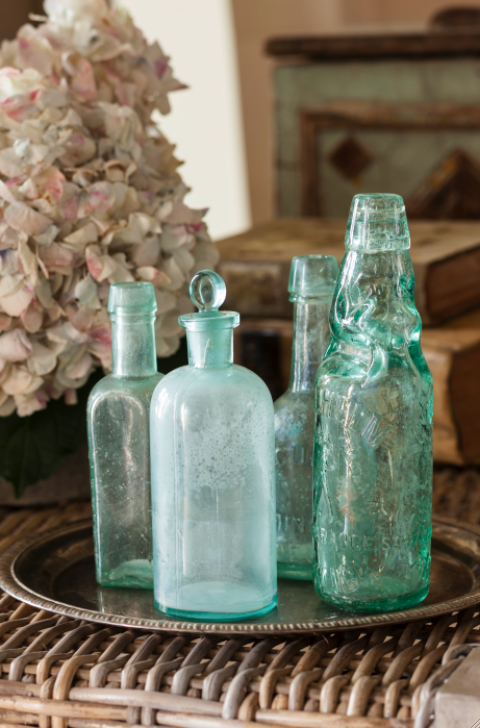 Green antique bottles in a French Country cottage on Hello Lovely Studio