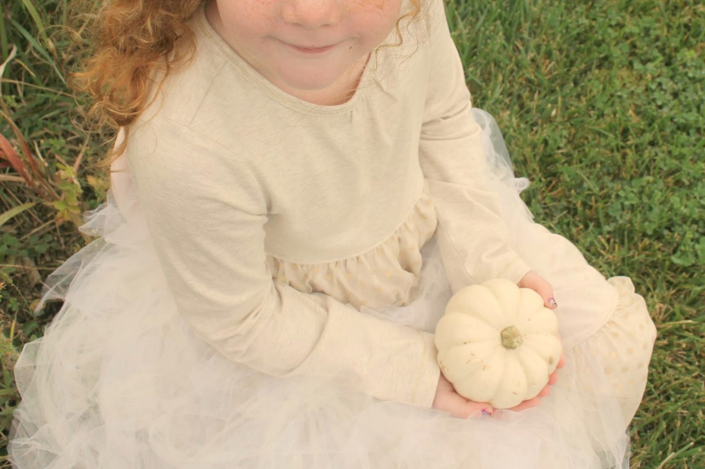 Red haired child holding baby boo pumpkin. Hello Lovely Studio.