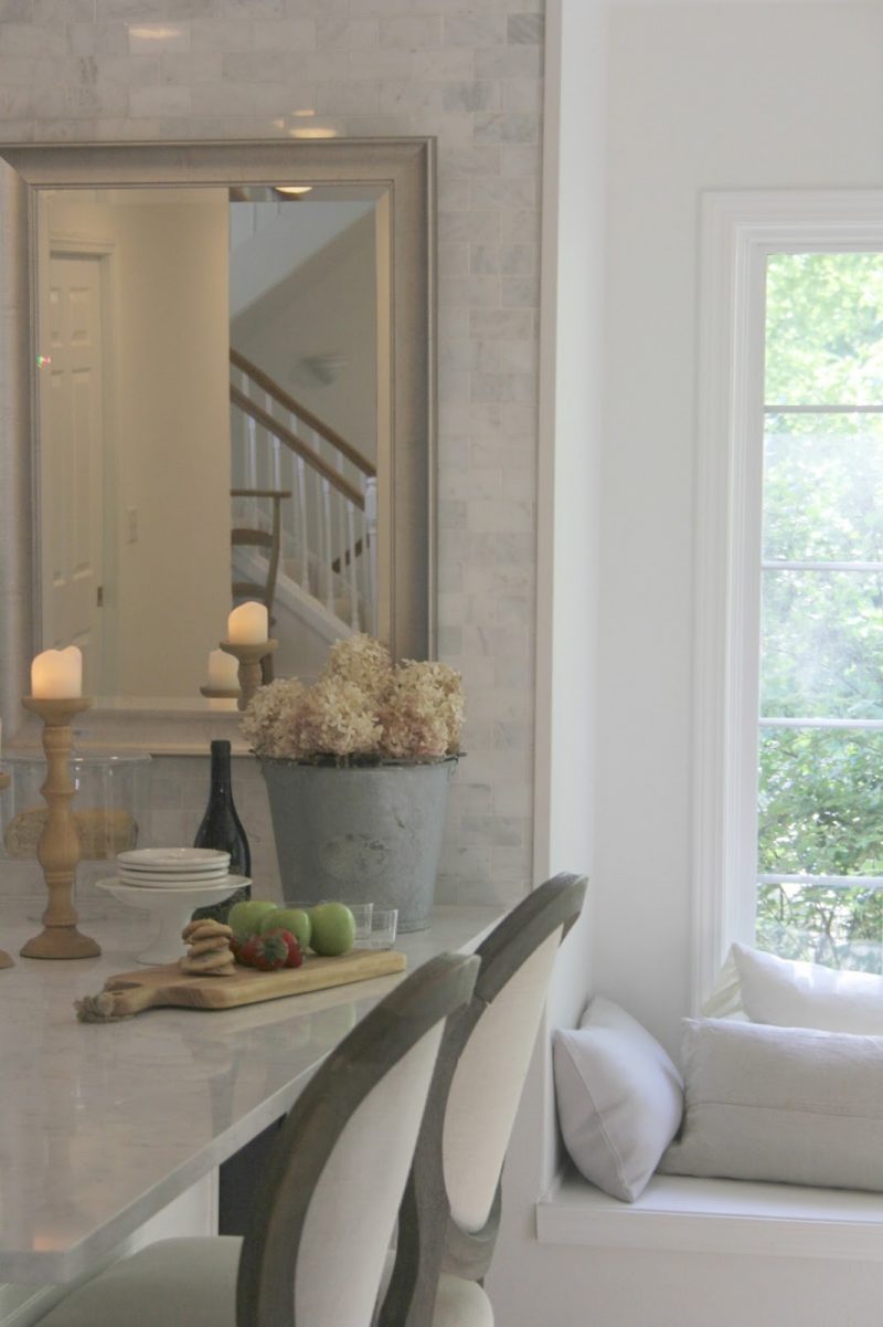 White kitchen with marble subway 
tile by Hello Lovely Studio