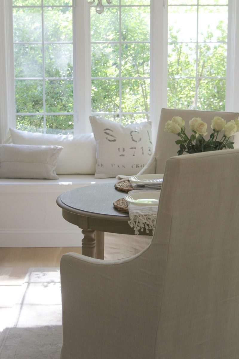 Serene white kitchen with window seat by Hello Lovely Studio