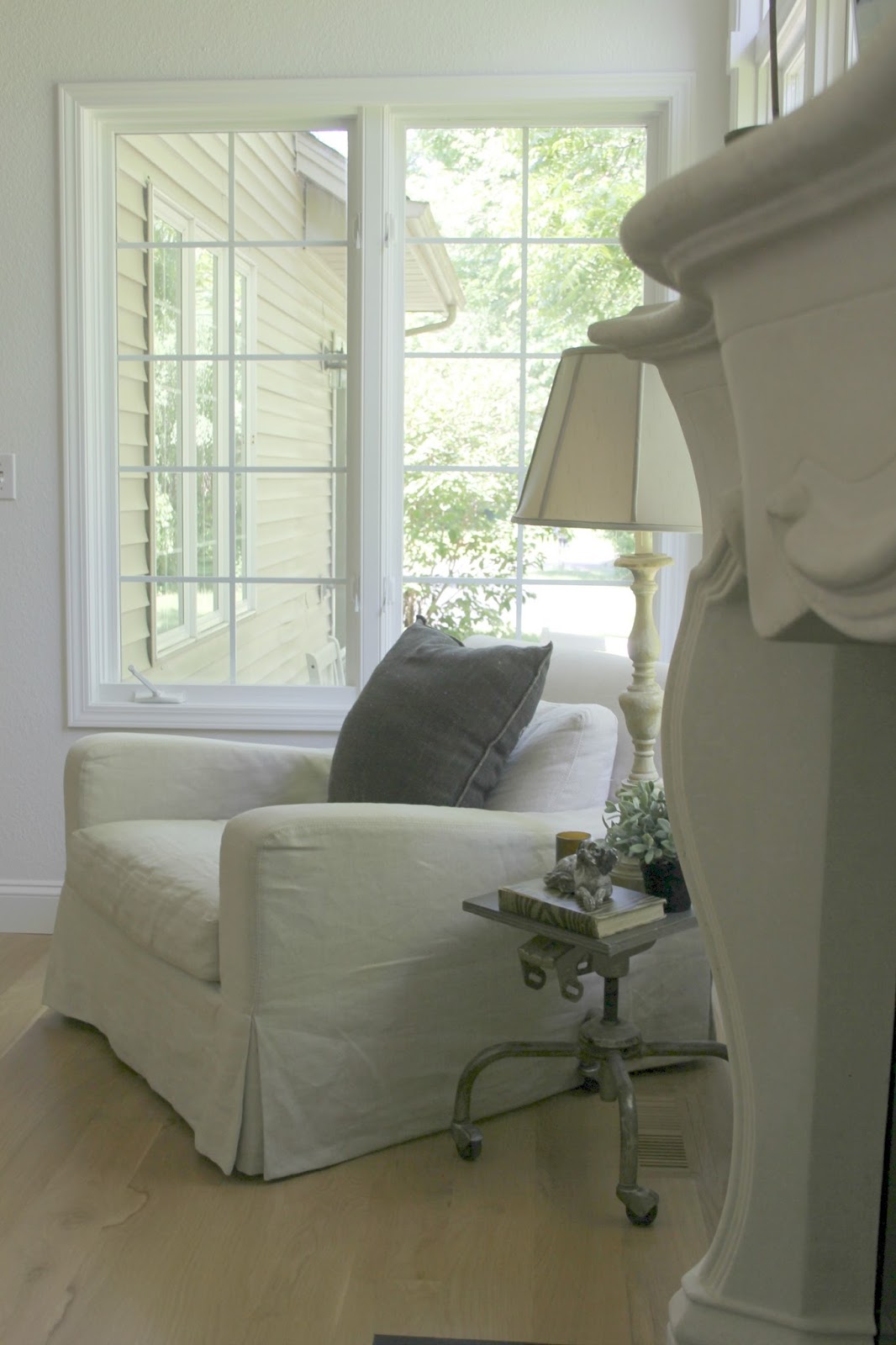 Belgian linen armchair and stone fireplace in renovated cottage by Hello Lovely