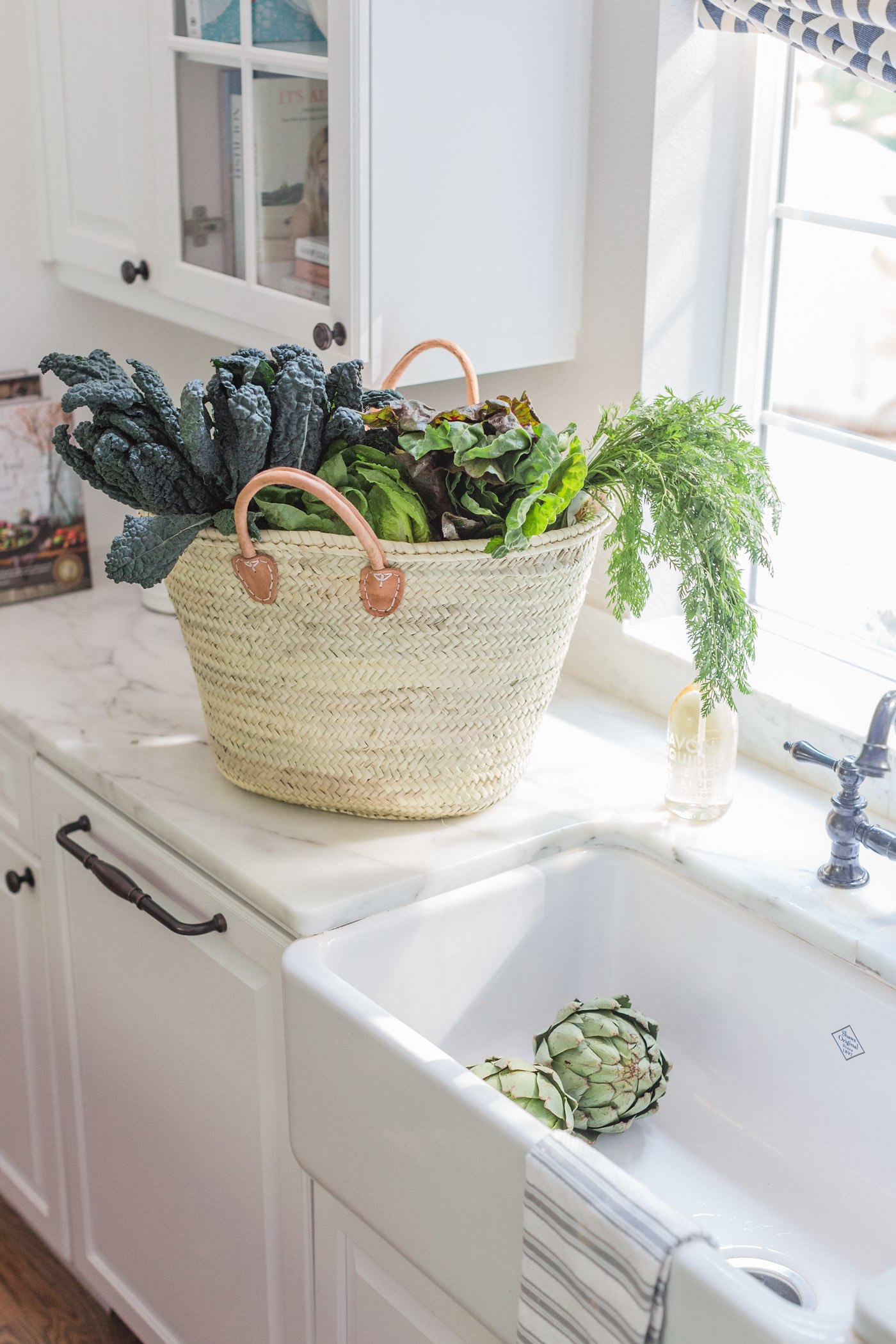 Beautiful white kitchen with market tote of farm fresh greens. Lemon Grove Lane.