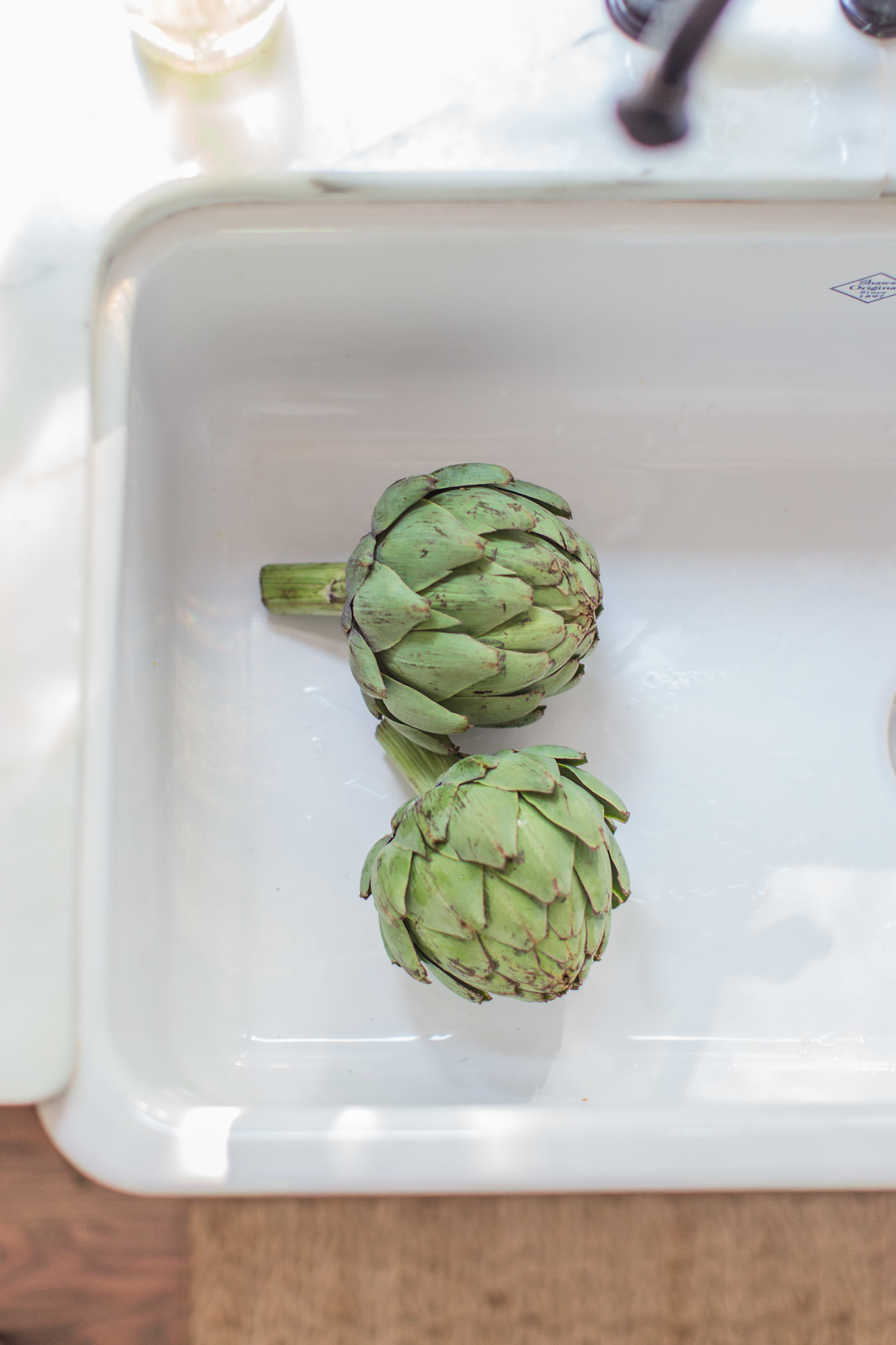 Beautiful artichokes in white farm sink by Lemon Grove Lane.