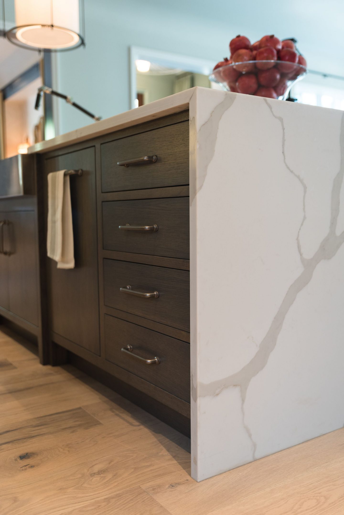 Moody kitchen island with waterfall quartz counter by Randi Stovesand for O'More Show House