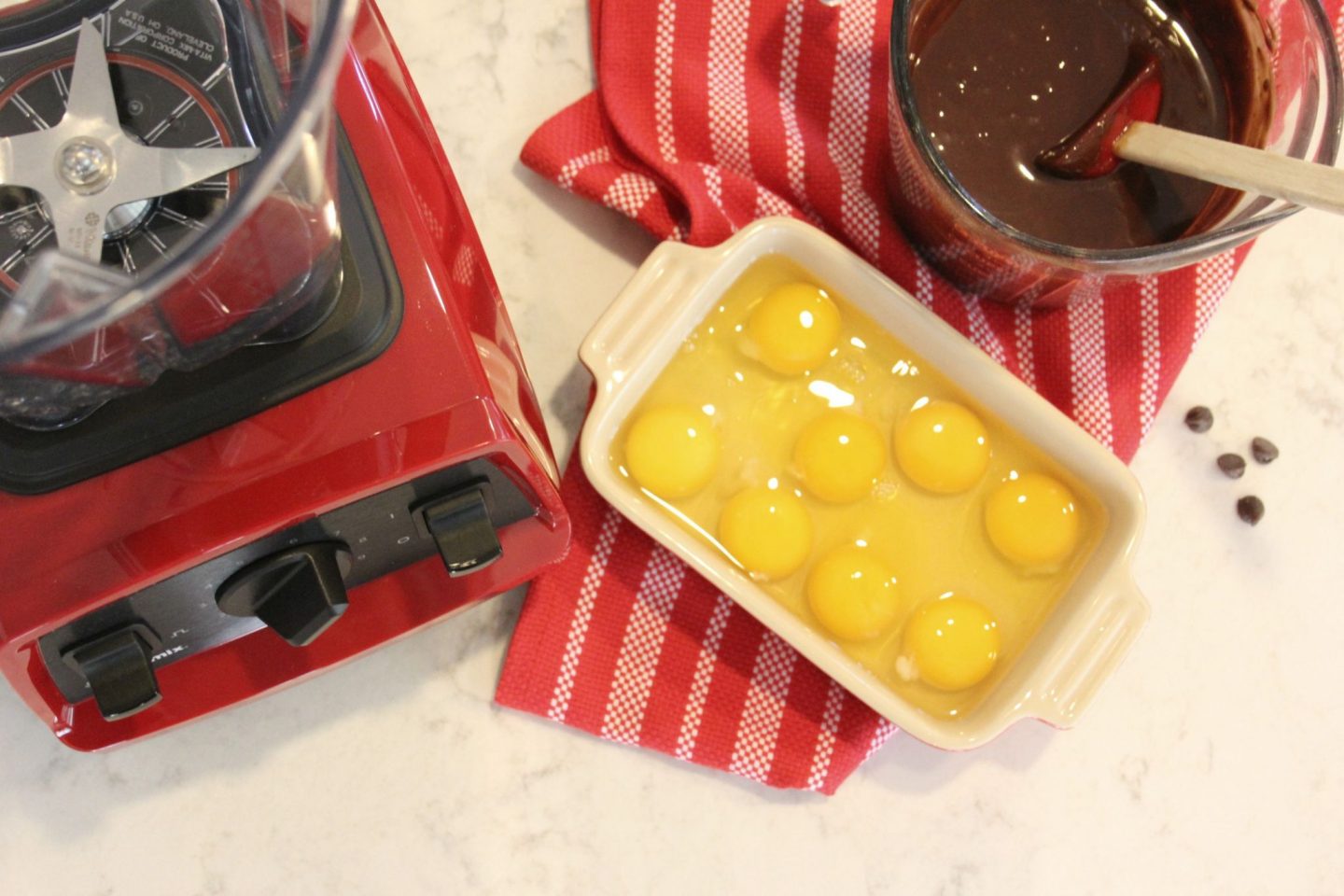 Red Vitamix Explorian E320 with eggs and chocolate on counter