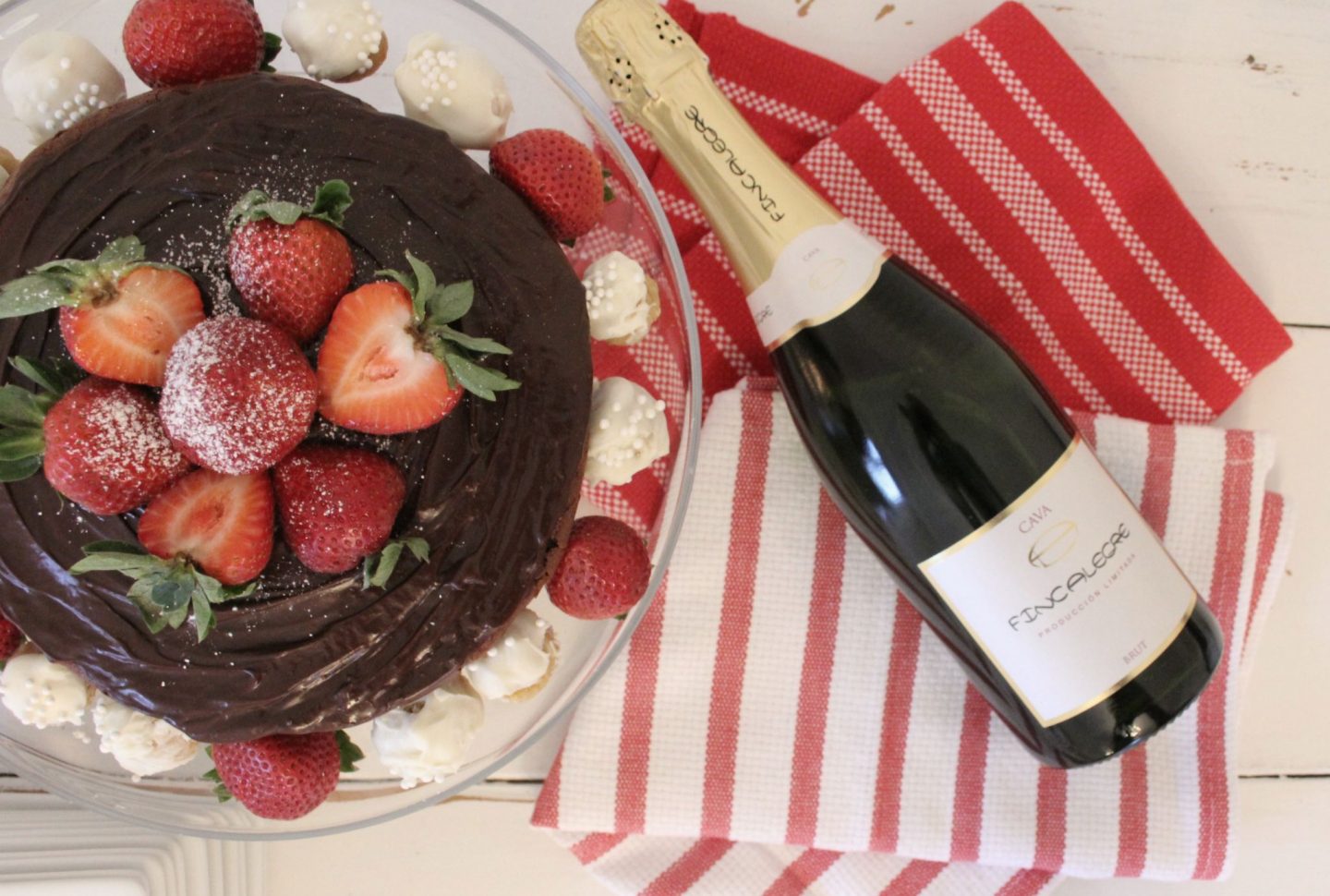 Beautiful chocolate cake, bottle of Cava, and red and white stripe dishtowels - Hello Lovely Studio