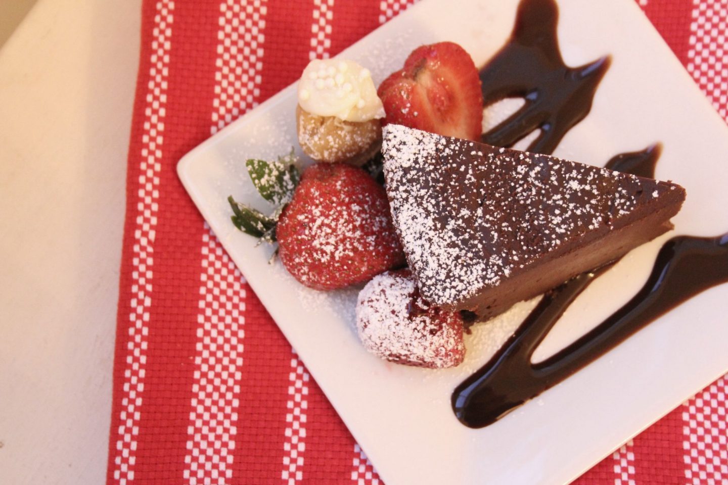 Slice of chocolate cake with strawberries and sugar cookie truffle