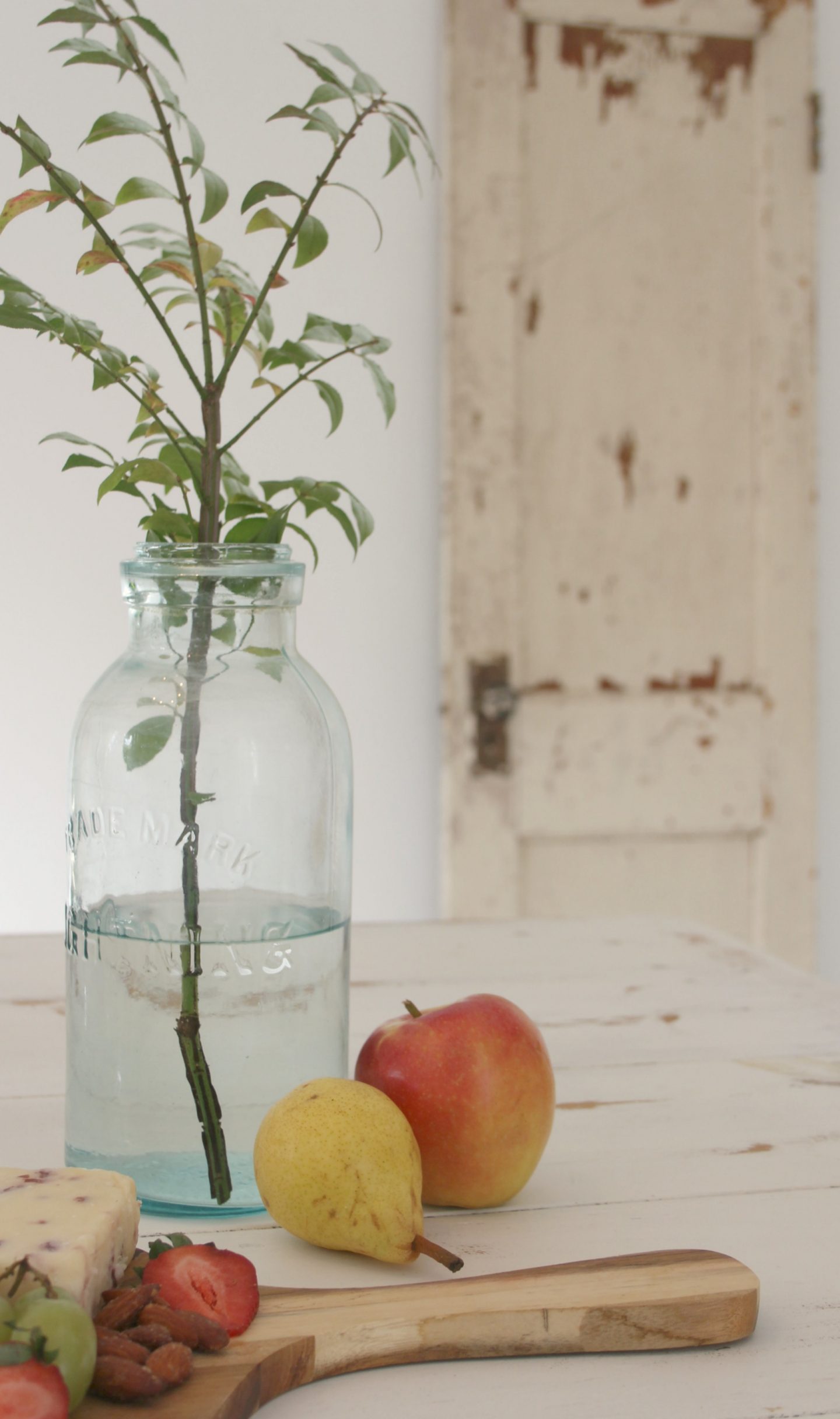 The beauty of an antique aqua Mason jar as a vase with charcuterie upon a distressed white harvest table - Hello Lovely Studio.