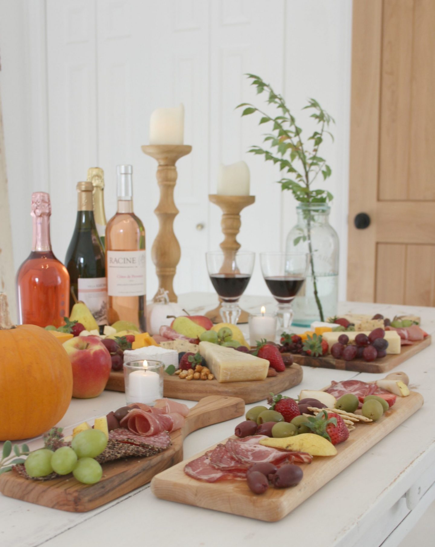 Beautiful cheese boards and wine on a white farmhouse table by Hello Lovely Studio