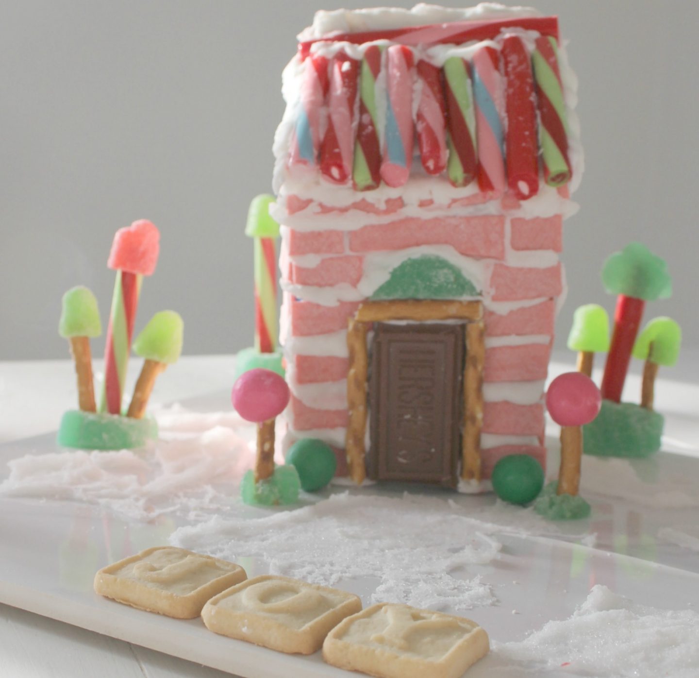 Whimsical and festive homemade pink candy house made with sticks of gum - Hello Lovely Studio. CLICK OVER to find Christmas Decor DIY Ideas to Get Crafting for the Holidays Right Now as well as Decorating ideas! #christmasdecor #pinkchristmas