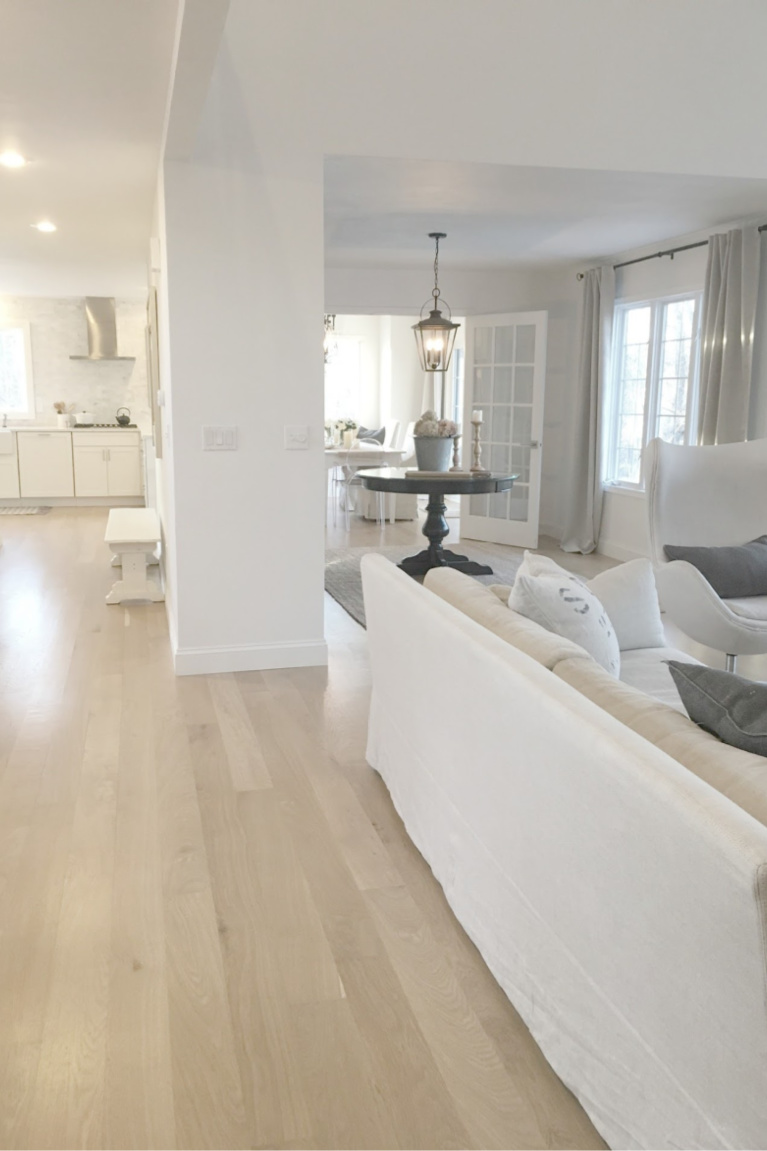 White oak hardwood flooring and Belgian linen furniture in our European country inspired cottage with white walls and serene decor. #hellolovelystudio #livingroom #whiteoak #europeancountry #frenchfarmhouse #belgianlinen #benjaminmoorewhite