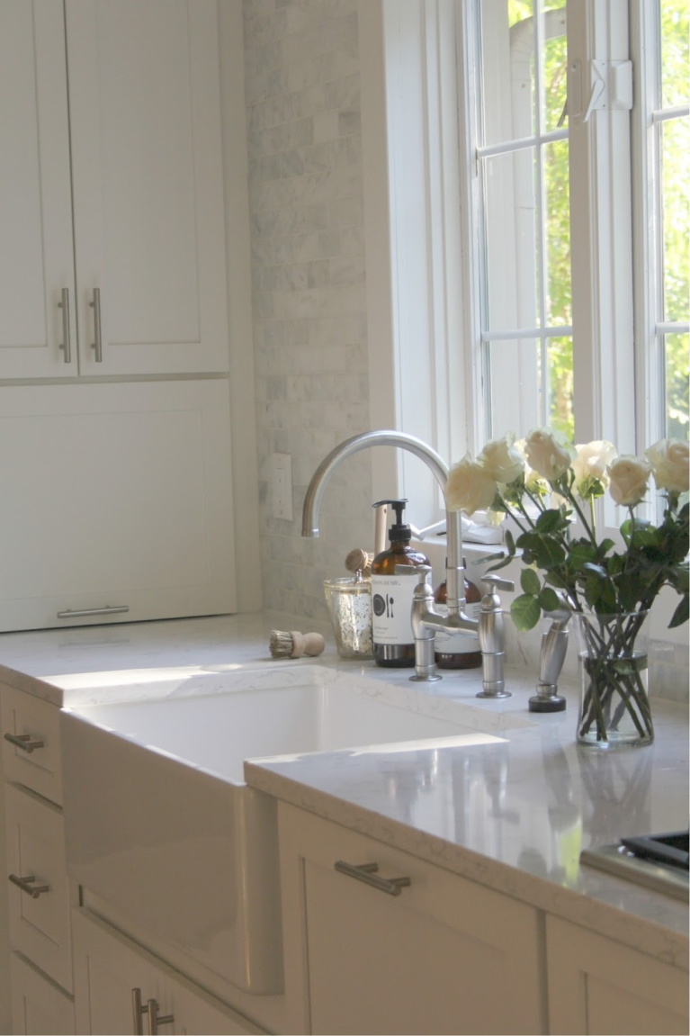 White Shaker cabinetry and apron front fireclay sink in my serene white kitchen with Viatera quartz (Minuet) and polished marble subway tile backsplash. Find a Soft, Ethereal European Country Kitchen Mood to Inspire Now! #hellolovelystudio 