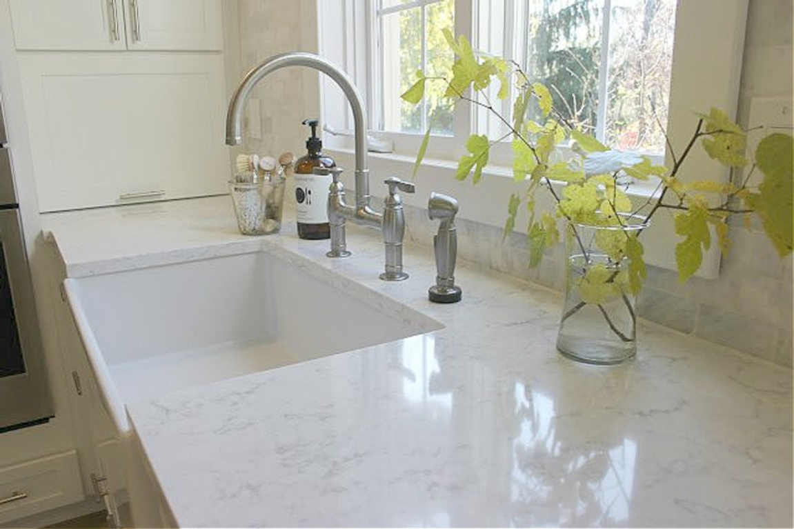 Viatera quartz countertop (Minuet) and fireclay farm sink in my serene white Shaker kitchen. #hellolovelystudio #viatera #whitequartz #minuet #quartzcontertop #farmsink #kitchendesign