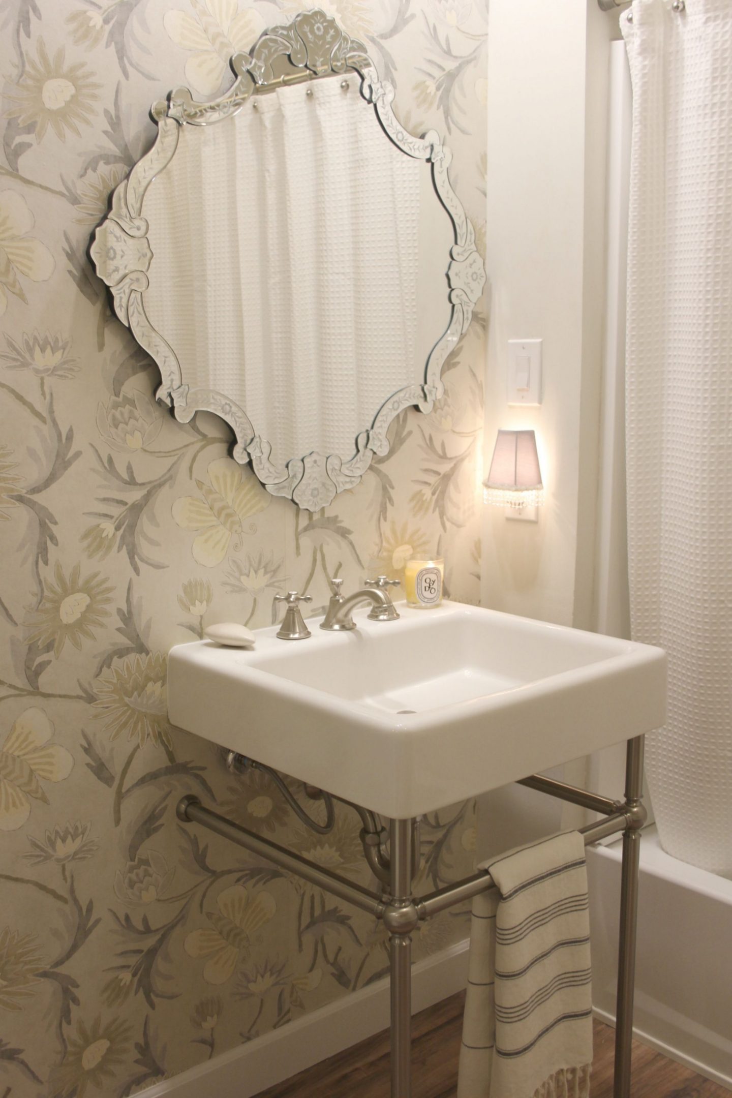 Classic white bathroom with console sink, Venetian mirror, Thibaut wallpaper (Lizette), and simple decor - Hello Lovely Studio.