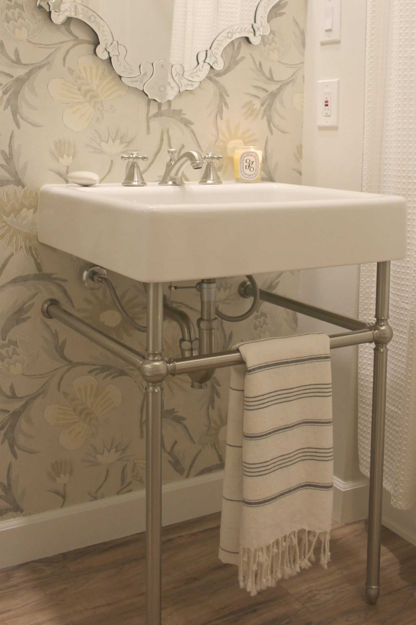 An elegant console sink, wallpaper, and a Venetian mirror in a classic, spa-like timeless classic bathroom by Hello Lovely Studio.