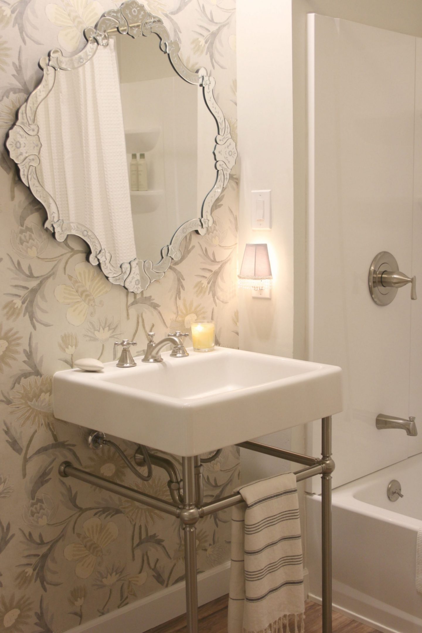 A subdued palette and classic style in this bathroom by Hello Lovely Studio with DXV Oak Hill bathroom console sink and Seabury widespread bathroom faucet (Grohe).