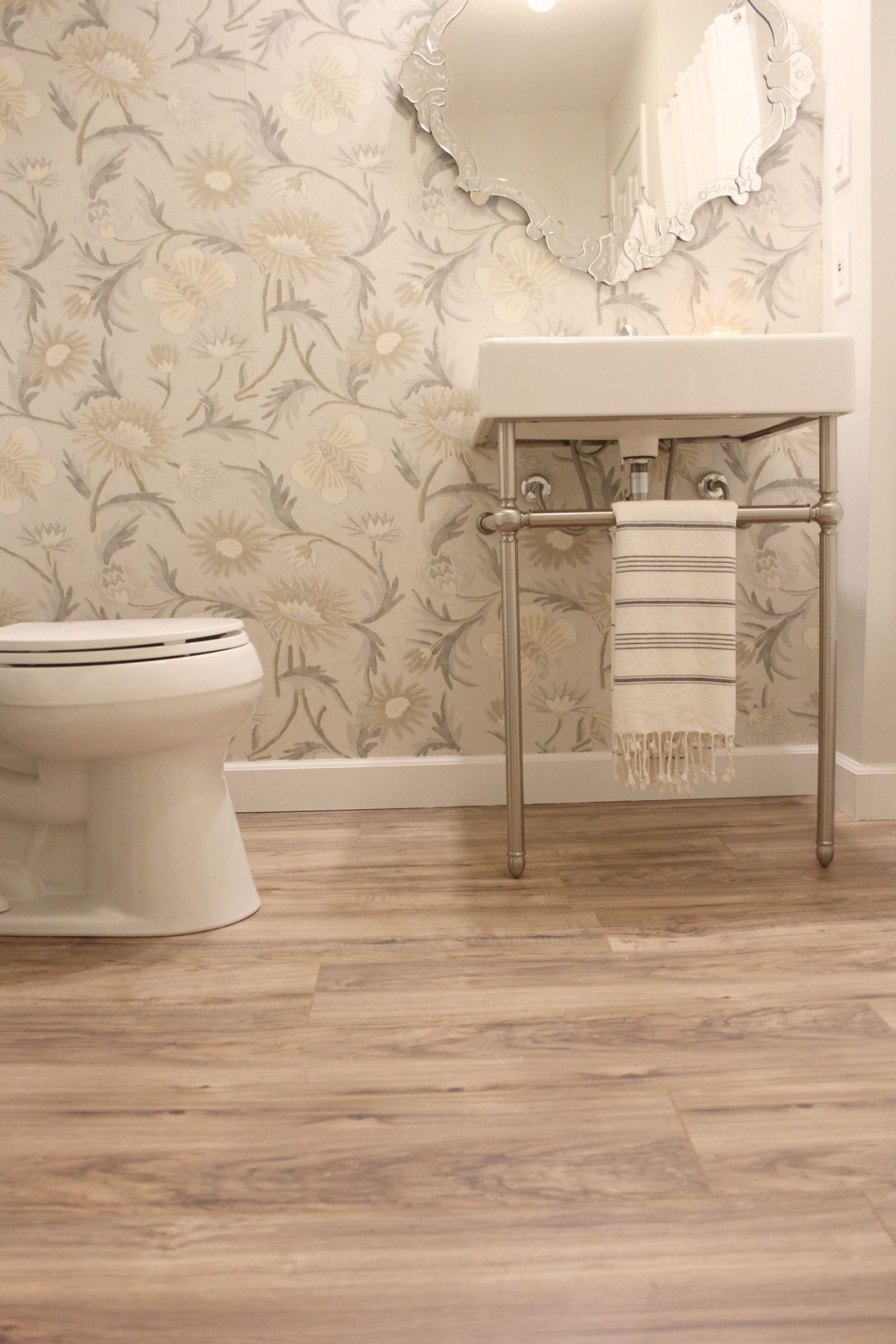 Classic and modern farmhouse decor elements combine in this bathroom with console sink (DXV Oak Hill) and Thibaut wallpaper.