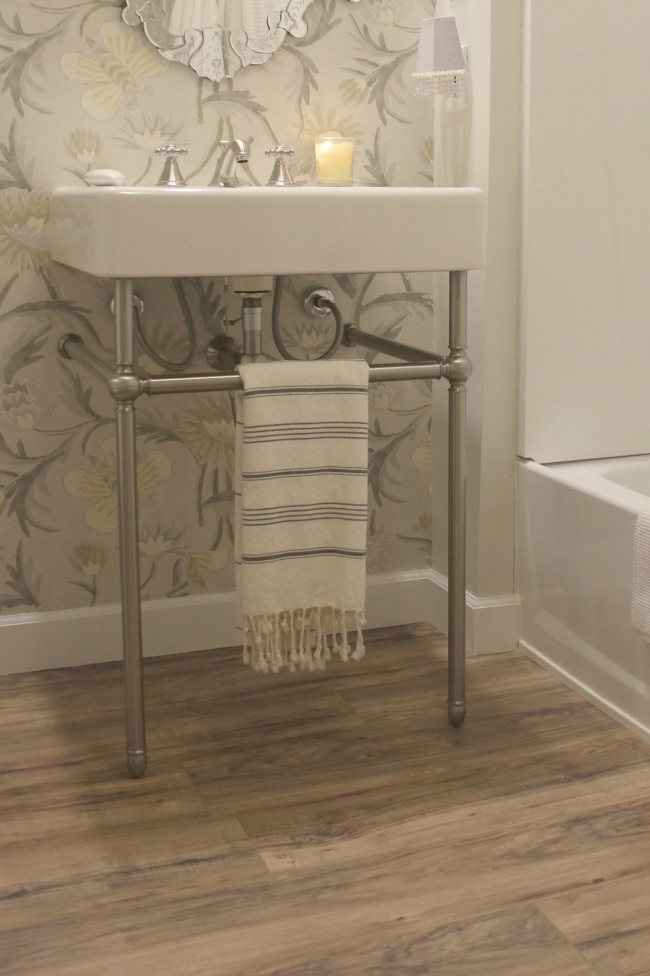 A striped Turkish towel is perfect on this console sink's metal base. Design by #HelloLovelyStudio - DXV Oak Hill Bathroom Console Sink. #consolesink #modernfarmhouse #bathroom