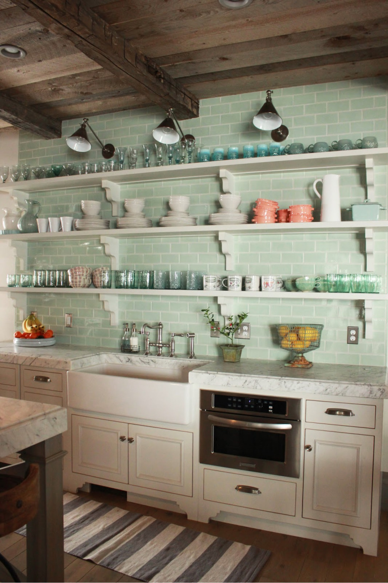 Open shelving and soft green subway tile backsplash in kitchen of Country French Old World style in a newly built custom cottage home in Utah - Decor de Provence. #countryfrench #interiordesign #oldworldstyle #europeancountry