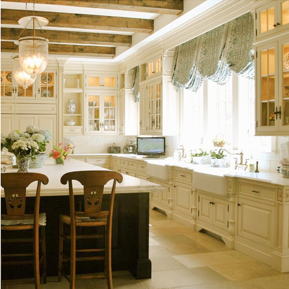 Gorgeouso blue and white French country kitchen with island, beams, and stone flooring - The Enchanted Home.