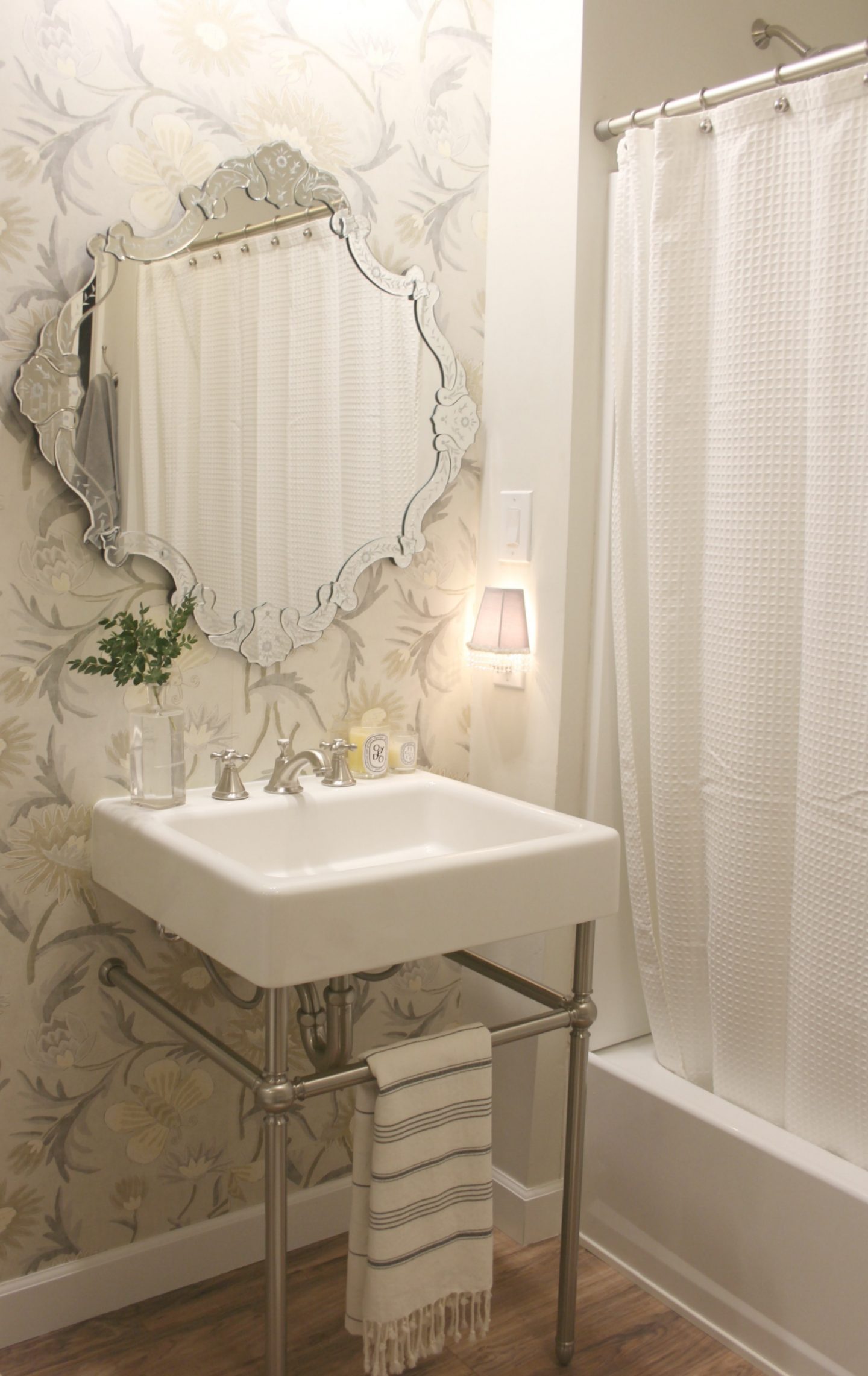 Classic white bathroom with console sink, Venetian mirror, Thibaut wallpaper (Lizette), and simple decor - Hello Lovely Studio.