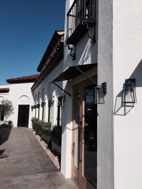 Exterior Magnolia Table Restaurant in Waco with black and white design, arches, window boxes, and modern farmhouse sconce lighting. #magnoliatable #exterior #restaurant #fixerupper