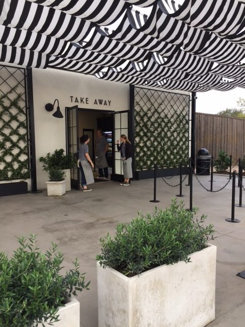 Magnolia Table Take out area with black and white stripe awning, living wall trellises, and concrete planters. #magnoliatable #blackandwhite #restaruant #fixerupper #takeout