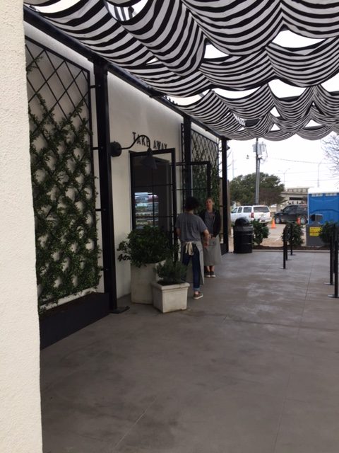 Magnolia Table Take Out area with black and white decor, barn style lighting, stripe awning, and modern farmhouse decor. #magnoliatable